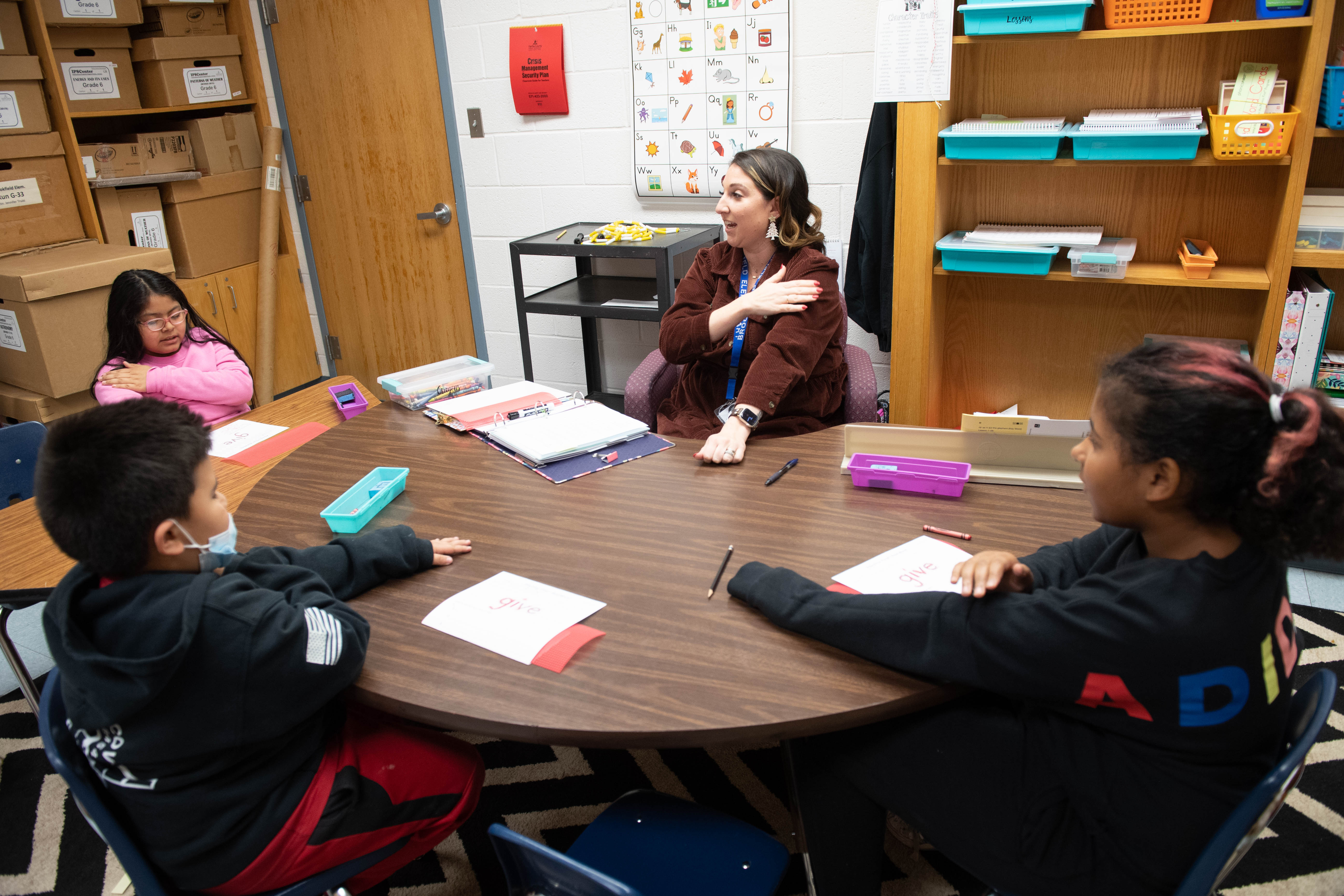 “Load it, tap it, trace it,” reading interventionist Jennings Johnston says as she directs three third-grade students working on how to overcome the tricky spelling of the word “give.”  “G-I-V-E, G-I-V-E, G-I-V-E,” the students say to themselves as they tap their arms once for each letter in the word. Then, they pick up “bumpy boards” or textured mats and trace out “g-i-v-e” with their fingers on top of them.