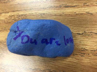 A rock with "You are loved" written on it